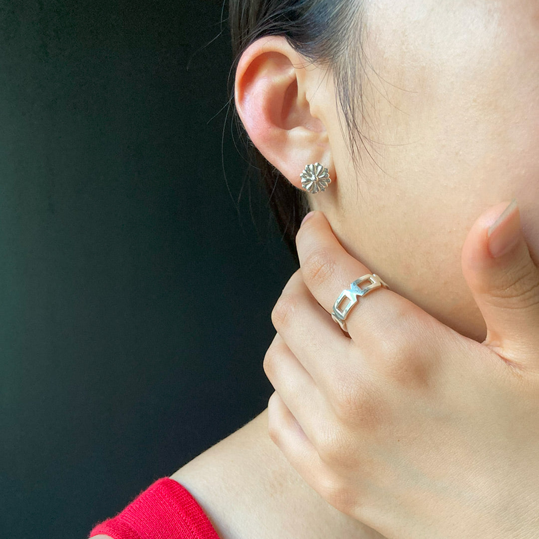 赤い服を着た女性が日本の菊の花をモチーフにしたピアスを着用 side angle ofwearing earrings with a japanese chrysanthemum motif